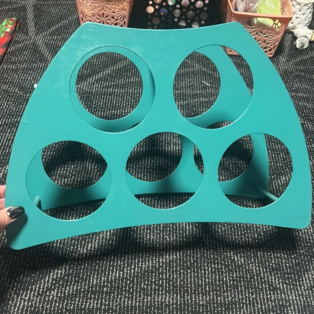 Turquoise wine holder that holds five bottles of wine.